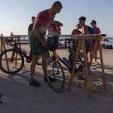 Ci troviamo in uno spiazzale situato di fronte alla spiaggia del quartiere San Girolamo, sul lungomare IX Maggio. Qui gli atleti hanno posto una sorta di rastrelliera dove sono posizionate le biciclette